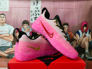 Angled side view showing the neon pink translucent upper, contrasting side logos, black-and-green laces, and sculpted outsole.