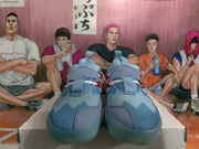 Front view of the blue sneakers showing textured uppers, wide tongue pull tabs, and red accent details.