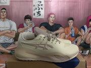 Side view of one cream and taupe basketball shoe with lace-up closure