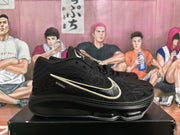 Side profile of a black Nike basketball shoe showing its textured upper and light-colored Swoosh.