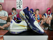 Angled view showing the textured white and dark purple uppers, yellow laces, Nike branding, and translucent outsoles.