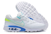 Side view of white Nike Air Max sneakers with turquoise swoosh outlines, blue sole accents, and a visible air unit; outsole shown.