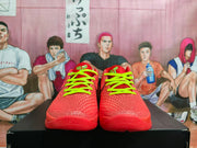 Front view of a pair of red basketball sneakers showing the textured toe boxes and bright lime-green laces.