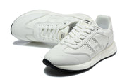 Pair of white lace-up sneakers shown at an angled top view.