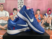 Angled view of blue Nike basketball sneakers displaying the textured uppers, white Swooshes, red heel details and white midsoles.