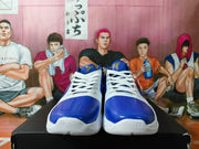 Front view of the blue and white Nike Kobe shoes, showing white laces and orange collar details.
