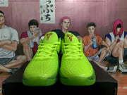 Front view of lime green Nike basketball sneakers with textured uppers, matching laces, and red tongue emblems.