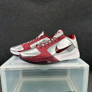 Three-quarter view of the pair showing silver toe panels, wine-red laces, Nike Swooshes, and visible outsole details.