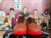Front view of the pair showing the dark laces, textured red-and-brown uppers, padded collars, and red outsoles.