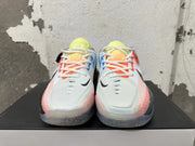 Front view showing white laces, black swoosh marks, and bright coral and yellow accents.