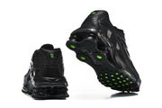Rear and outsole views of black Nike Shox Ride 2 sneakers with green accents.