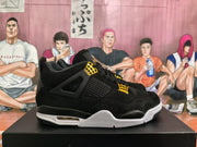Side profile of a black sneaker showing mesh paneling, gold-toned lace hardware, and a layered white-and-black sole.