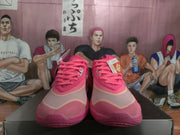 Front view of the pink sneakers showing pink laces, layered toe panels and textured outsoles.