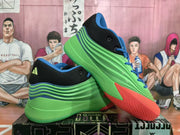 Angled view of the Adidas basketball sneakers highlighting the layered green side panels, blue details and red toe area.