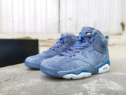 Three-quarter view of the pair of blue high-top basketball sneakers beside a black box.