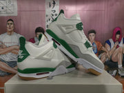 Angled view of a pair of white and green sneakers showing the side panels, green accents, gray overlays, and gum-colored outsole.