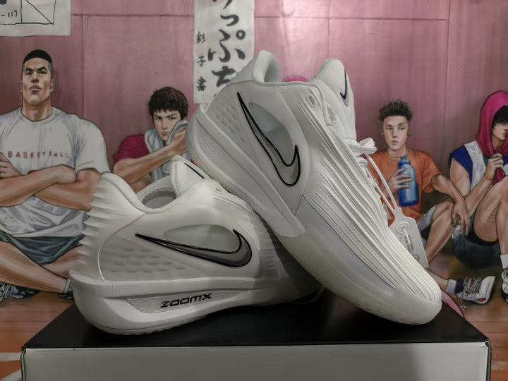 White Nike sneakers displayed on a box, showing black Swoosh branding, side panel texture and a visible ZoomX mark.