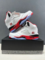 Pair of white and red high-top sneakers arranged on a box, showing mesh side panels, black midsole sections, and translucent outsole areas.