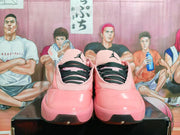 Front view of pink Jordan basketball shoes with black patterned laces