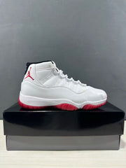 Side profile of the white and red sneaker displayed on a black shoebox.