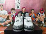 Front view of a pair of white, grey, and black Jordan 4-style sneakers.
