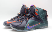 Pair of high-top basketball sneakers shown from a front three-quarter angle with dark uppers, green side panels, and orange details.