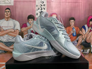 Two pale blue Nike basketball sneakers arranged on a black box, showing the side branding, layered panels, and low-cut silhouette.