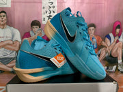 Angled view of blue Nike basketball sneakers showing the black-and-white side Swooshes, perforated panels, and gum-colored outsole.
