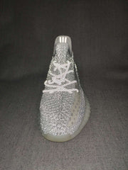 Top-front view highlighting the textured knit upper, lace arrangement, tongue, and translucent outsole.
