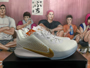 Side view of a white basketball sneaker showing a gold Nike Swoosh, dotted side detailing, and a translucent outsole.
