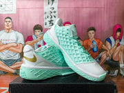 Angled view of white and mint green Nike basketball sneakers showing the textured side panels, laces, gold Swoosh, and patterned outsole.