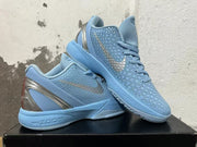 Pair of light blue Nike basketball shoes displayed together, showing the textured uppers and metallic-looking heel accents.