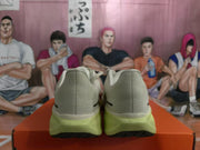 Rear view of the pair showing the gray heel panels, black accents, and light yellow-green soles.
