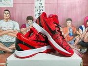 Pair of red, black, and white Nike basketball sneakers displayed on a box, showing the side profile and textured upper.