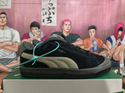 Side view of a black Puma sneaker with taupe side stripes