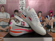Angled view of white Nike basketball sneakers showing the textured upper, black Swoosh and colorful sole details.