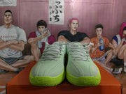 Front view of gray-green Nike basketball shoes showing perforated toe panels and bright green outsoles