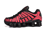 Side view of a black and bright pink sneaker with Shox columns and Swoosh detail.