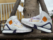 Pair of high-top shoes shown from the side, with purple, gold, and orange accents