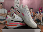 Angled view showing the textured white uppers, black side Swooshes, and peach-pink and orange details.