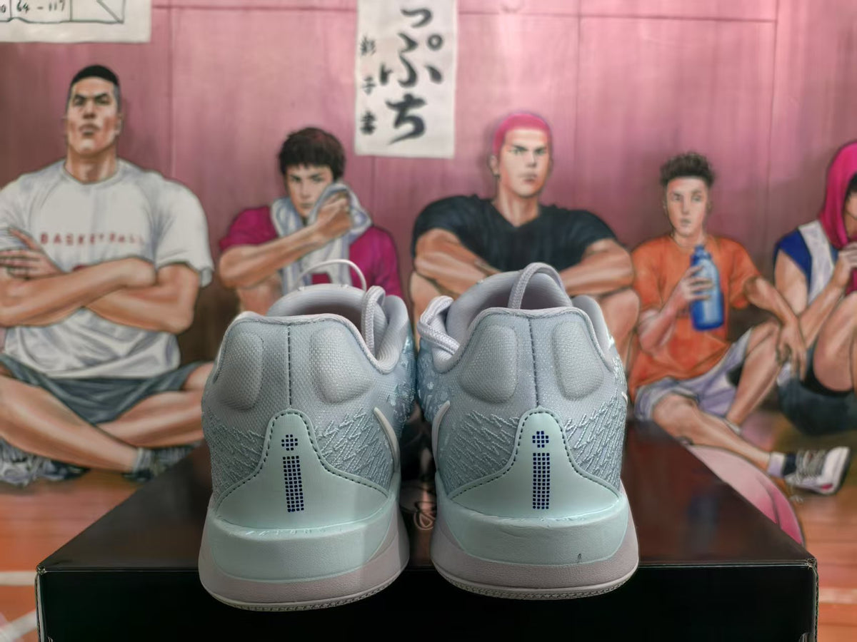 Rear view of pale blue Nike basketball sneakers resting on a black box, showing padded heel panels and tonal rear detailing.