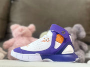 Close side view highlighting the purple upper, white panels, orange perforated detail, and outsole.