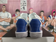 Rear view of white basketball shoes with blue heel panels and gray midsoles.