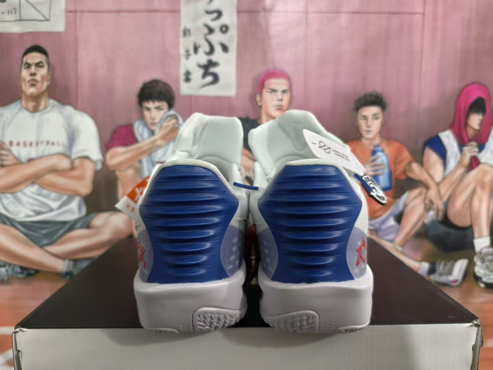 Rear view of white basketball shoes with blue heel panels and gray midsoles.