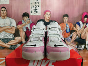 Front view of white and pink Nike sneakers with black Swoosh details and sprinkle-like accents.