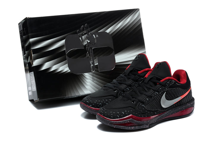 Pair of black and red Nike low-top basketball shoes beside a black patterned shoe box