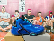 Side view of a blue Nike basketball sneaker showing turquoise accents and a prominent black side support piece