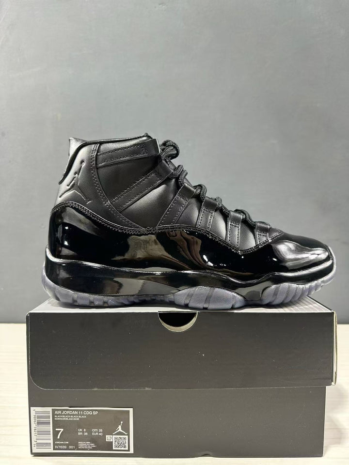 Black high-top sneaker displayed on its box with a visible label identifying Air Jordan 11 CDG SP, style code LV7639-001, and EU 40 sample sizing.