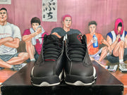 Front view of black high-top sneakers with black laces, red Jordan branding, and white outsole accents.