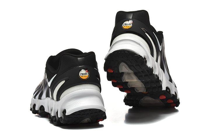 Rear and outsole views of black-and-white Nike sneakers with visible circular sole elements.